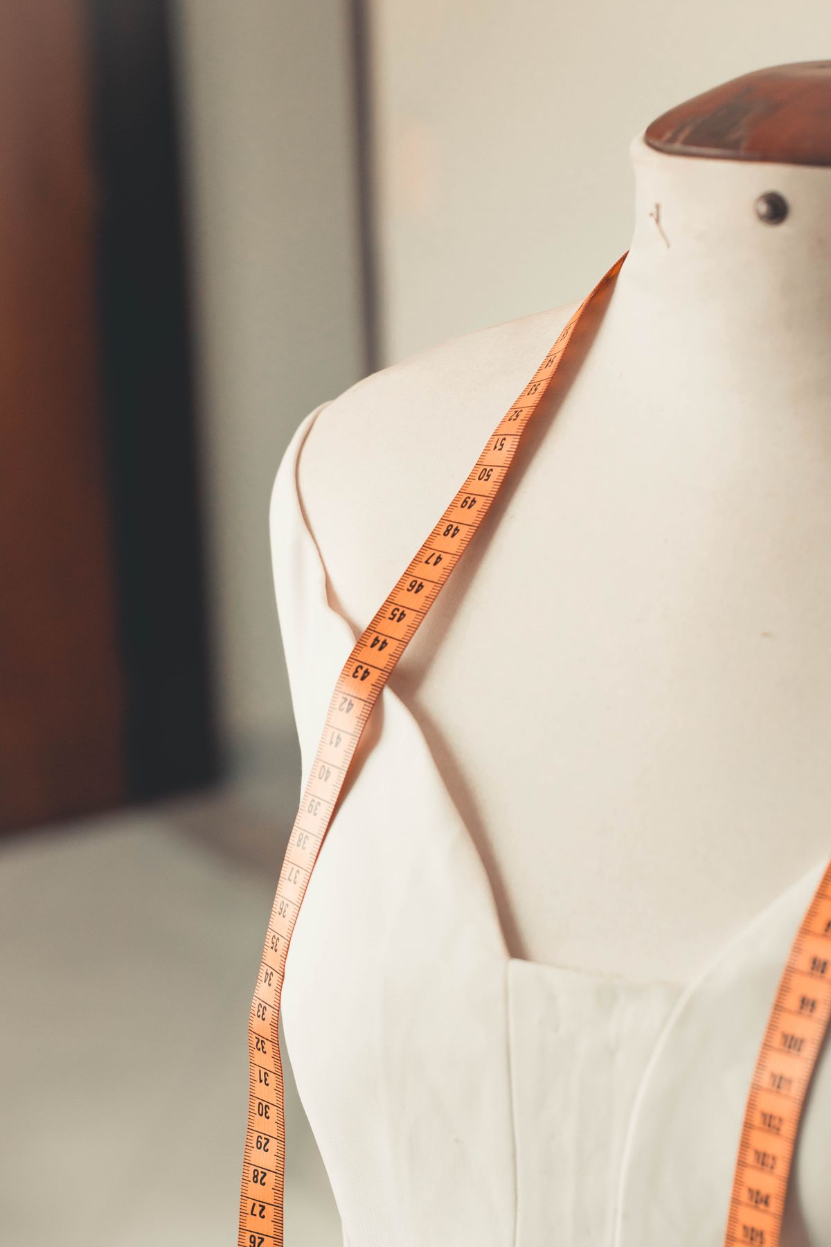 Measuring tape draped over a dress form